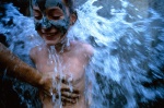 Greek Spas, Kyllini. Child covered with mud washes under healing sulphur waterfall  
 © Maro Kouri