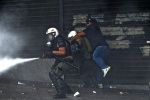 Riots during a rally against plans for new austerity measures///Protesters clash with riot police while they throw teargas
 © Maro Kouri